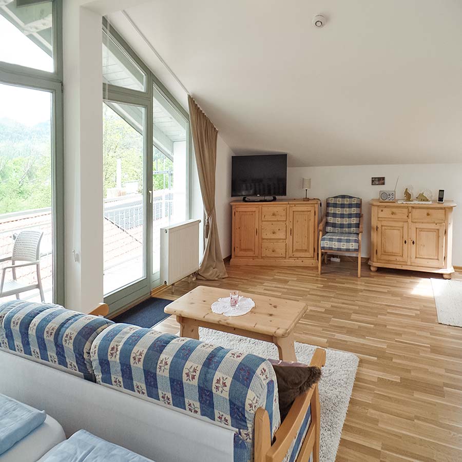 Wohnbereich der Ferienwohnung Kranzhorn mit Panoramafenster und Balkon